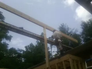 Carpenter setting a ridge beam over a new addition frame — Ice Dam Removal by Roofing Brothers in Newbury