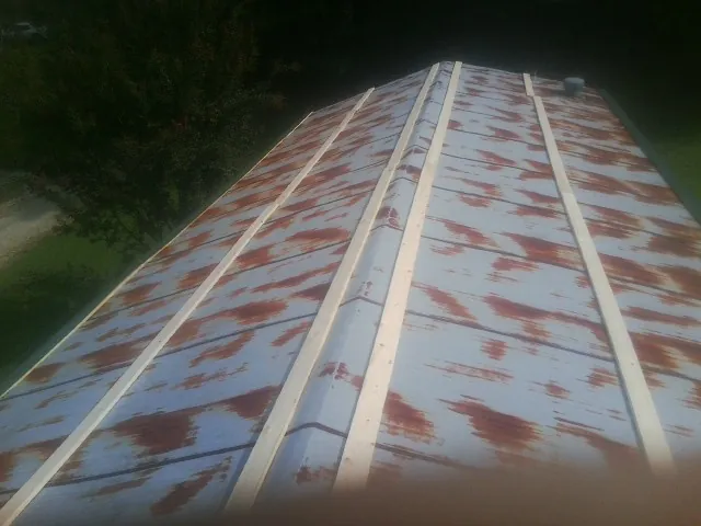 Rusted metal roof panels with new wood purlins before replacement — Storm Damage Roof Repair in Newbury by Roofing Brothers