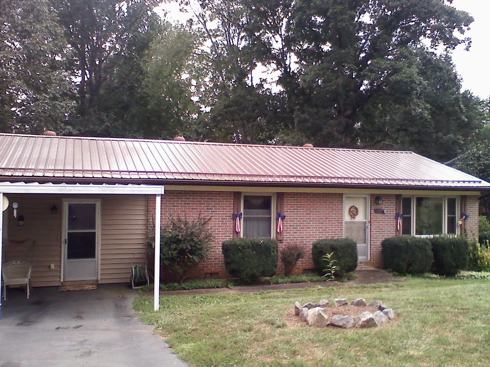 Bronze metal roof and carport on a brick ranch home — Roof Repair work by our crew in Newbury